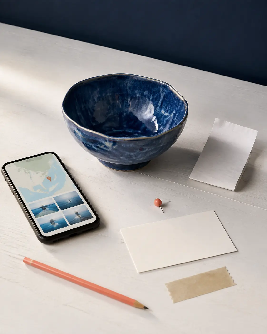 Handmade cobalt bowl beside phone, map and packing clues used to find its maker