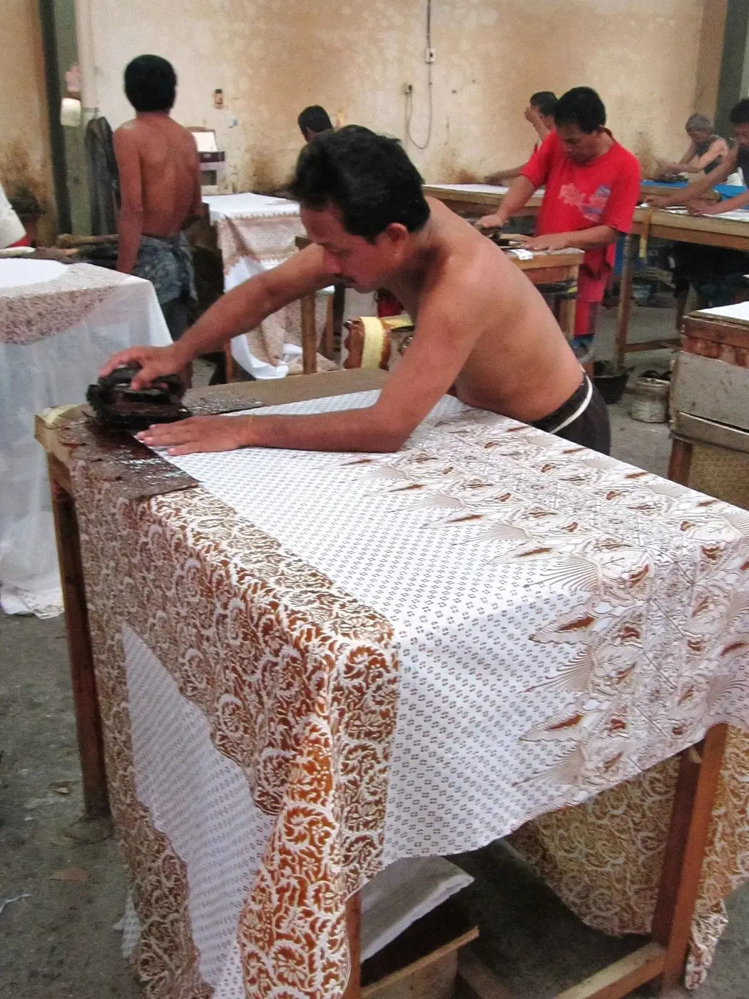 A craftsperson applying wax while making batik in Yogyakarta, Indonesia