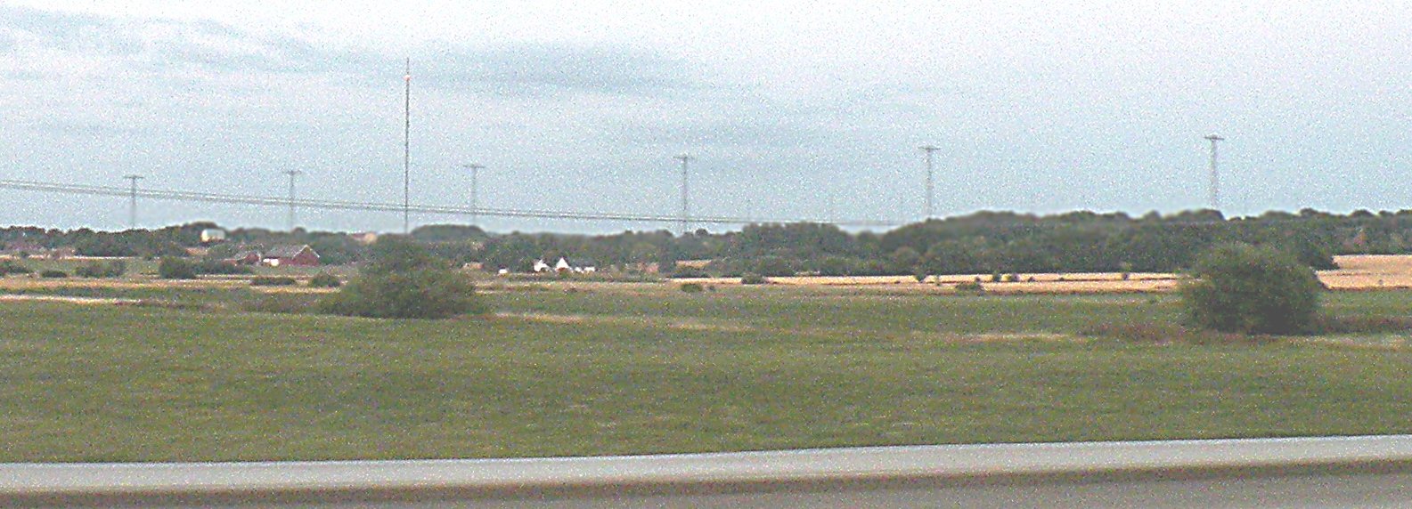 Grimeton Radio Station buildings and tall steel antenna towers beneath a cloudy sky