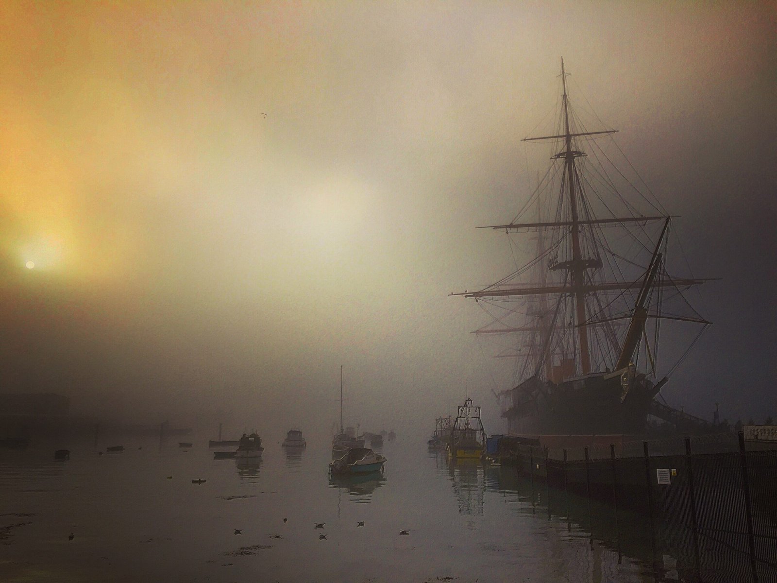 Restored HMS Warrior iron-hulled warship moored in a misty Portsmouth harbour