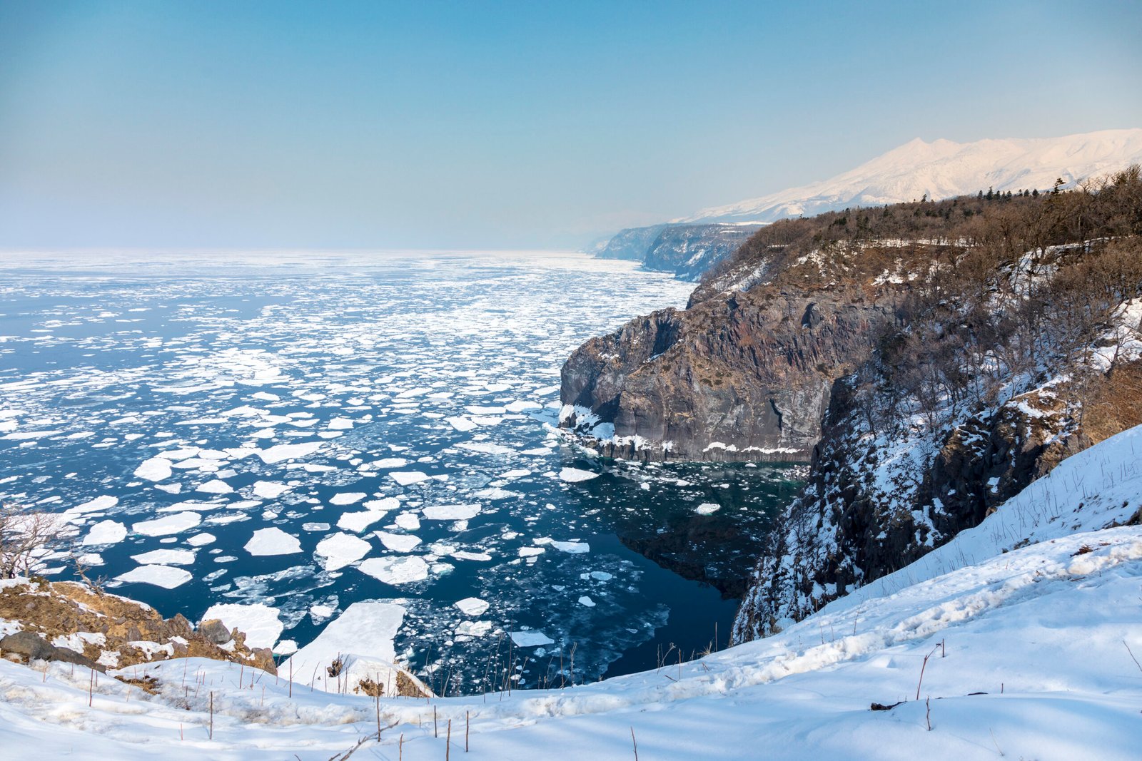 Seasonal drift ice floating beside the snow-covered Shiretoko Peninsula on the Sea of Okhotsk